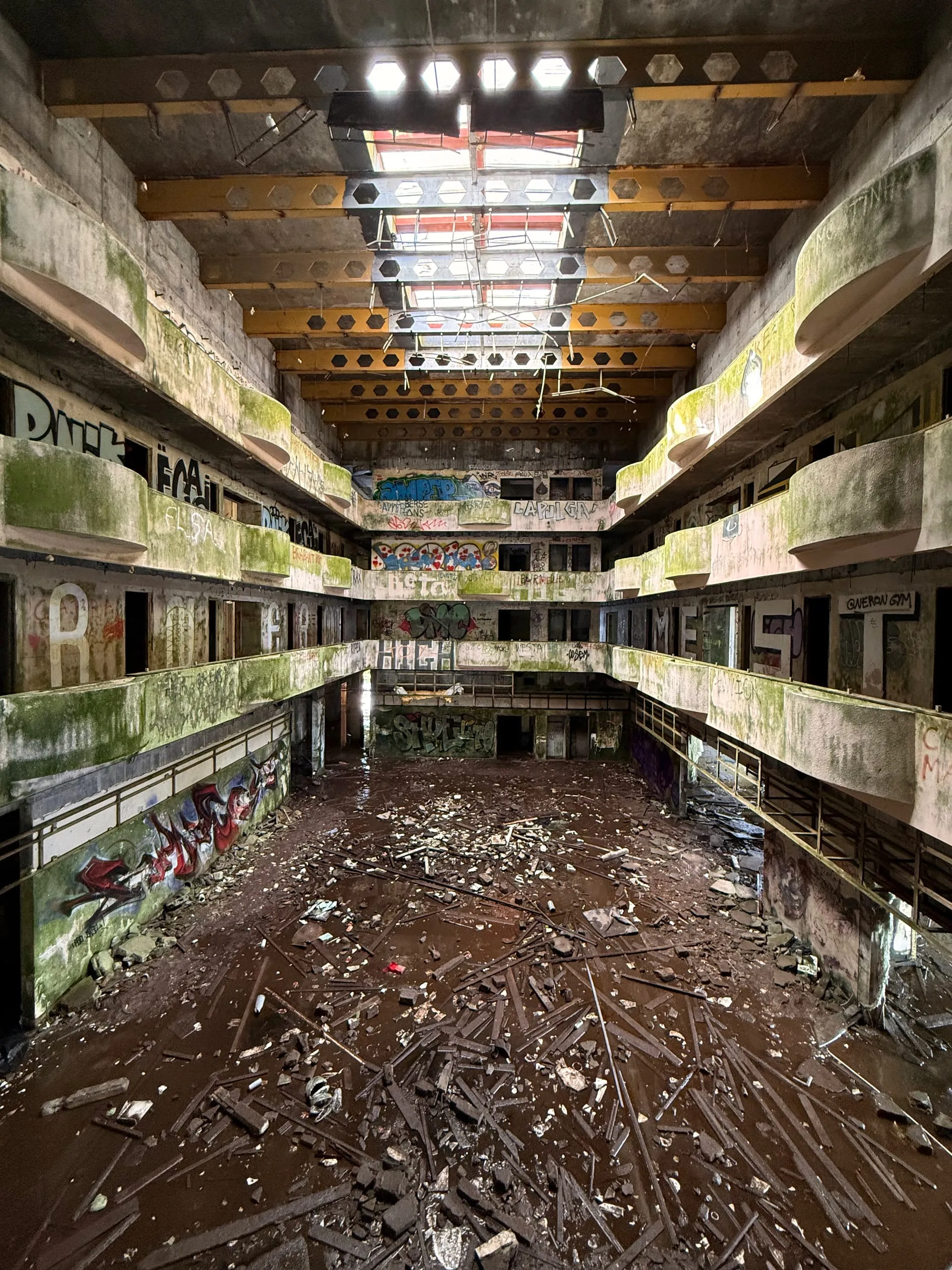 The decaying multi-storey atrium of an abandoned grand hotel above the Azores crater lakes