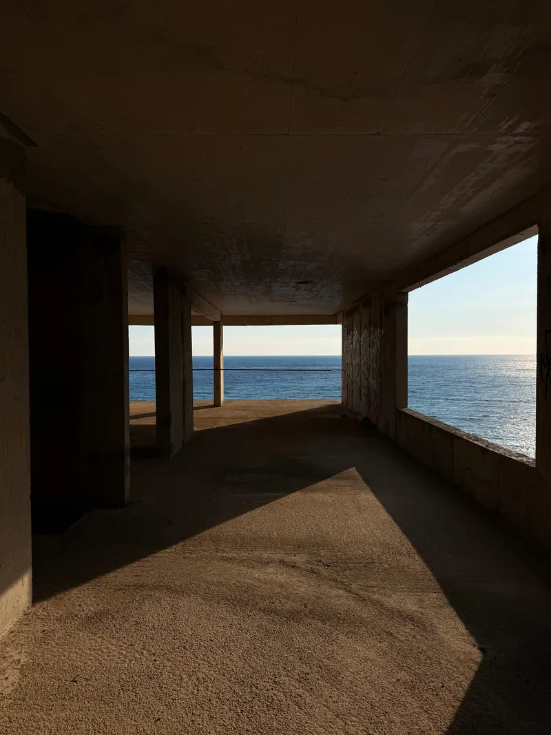 Concrete colonnade of an abandoned seaside hotel opening onto the Adriatic