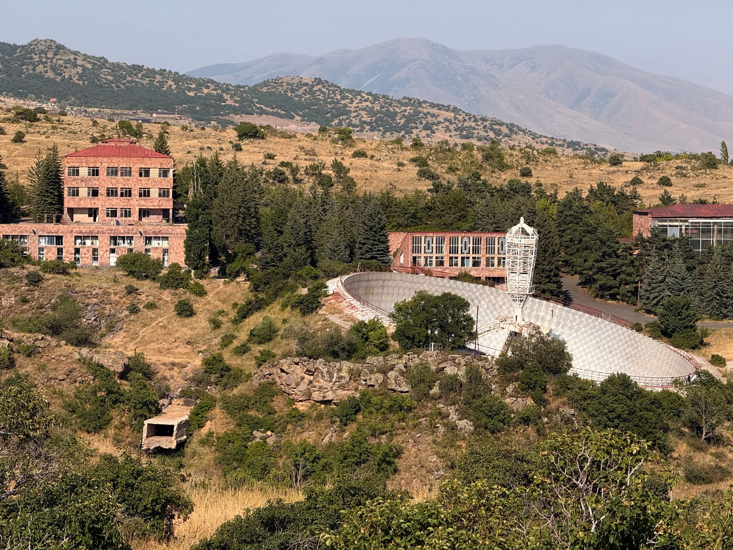 The 54-metre dish set into the hillside with its secondary tower standing in the bowl, institute buildings above it and the mountains behind